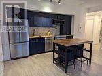 Toronto (High Park-Swansea) condo for rent - A kitchen with a table and chairs in the middle.
