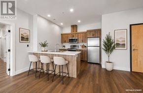 Charlottetown condo for rent - A modern kitchen with a bar area and a refrigerator.