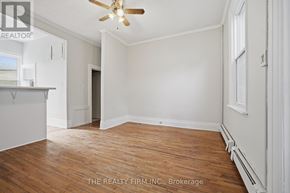 London South (South F) fourplex for rent - A room with a ceiling fan and wood flooring.