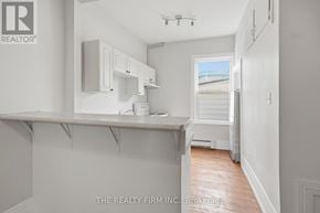 London South (South F) fourplex for rent - A white kitchen with a window and a view of the outside.