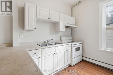 London South (South F) fourplex for rent - A white kitchen with a sink and stove.