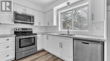 London South (South F) multi-family for rent - A kitchen with white cabinets and a stainless steel oven.