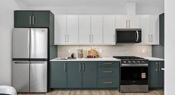 North York apartment for rent - A kitchen with green cabinets and a stainless steel refrigerator.