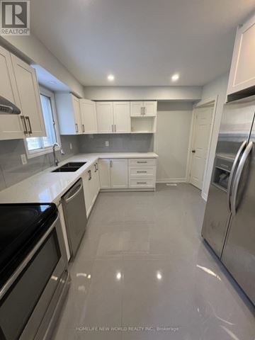 Toronto (Milliken) apartment for rent - A kitchen with white cabinets and a black stove top oven.