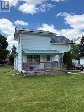 Kawartha Lakes (Lindsay) multi-family for rent - A white house with a porch and a car parked in front.