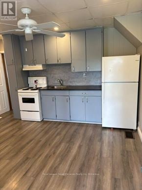 Kawartha Lakes (Lindsay) multi-family for rent - A kitchen with a white refrigerator, a white stove, and a white ceiling fan.
