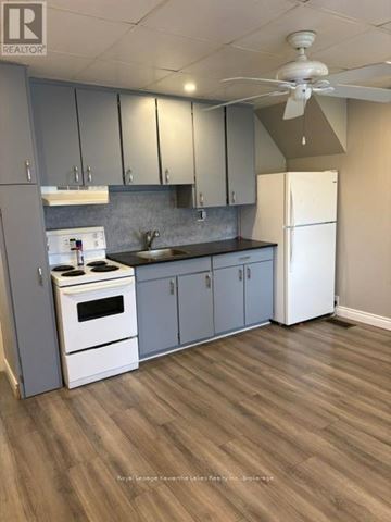 Kawartha Lakes (Lindsay) multi-family for rent - A kitchen with a white stove and a white refrigerator.