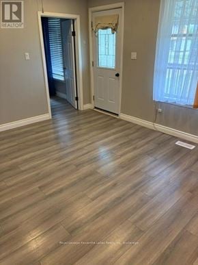 Kawartha Lakes (Lindsay) multi-family for rent - A room with wooden flooring and a doorway leading to another room.