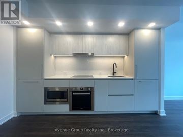 Toronto (North St. James Town) condo for rent - A modern kitchen with white cabinets and stainless steel appliances.