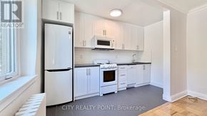 Toronto (Casa Loma) condo for rent - A kitchen with white cabinets and appliances.