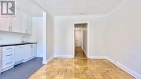 Toronto (Casa Loma) condo for rent - A kitchen with white cabinets and a wooden floor.
