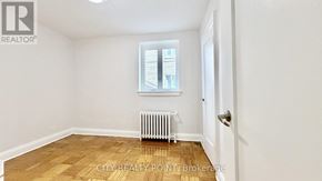 Toronto (Casa Loma) condo for rent - A room with a window, a radiator, and a door.