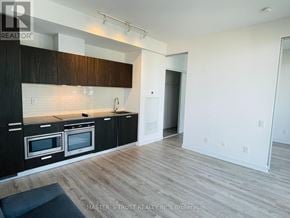 Toronto (Church-Yonge Corridor) condo for rent - A kitchen with black cabinets and white walls.