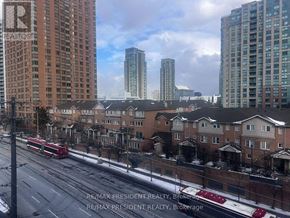 Toronto (Bendale) condo for rent - A city street with apartment buildings and a red bus.
