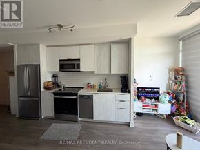 Toronto (Bendale) condo for rent - A kitchen with white cabinets and appliances, a ceiling fan, and a rug on the floor.