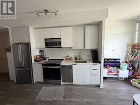 Toronto (Bendale) condo for rent - A kitchen with white cabinets and a black fridge.