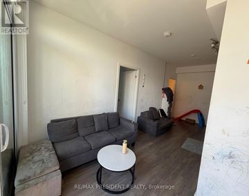 Toronto (Bendale) condo for rent - A living room with a grey couch and a white coffee table.