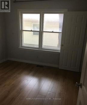 Newmarket (Huron Heights-Leslie Valley) apartment for rent - A room with a wooden floor and a white door.