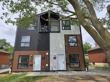 North York apartment for rent - A modern two-story house with a mix of dark and light wooden siding.