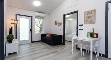 North York apartment for rent - A living room with a black couch and a white table.