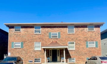 Louisville apartment for rent - A red brick building with a white door and windows.