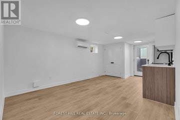 Scarborough apartment for rent - A spacious room with wooden flooring and white walls, with a reception desk on the right side.