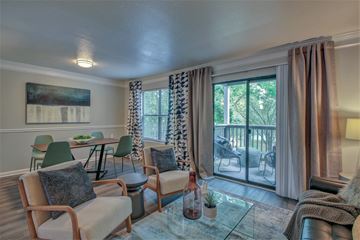 Little Rock apartment for rent - A living room with a glass table and chairs.