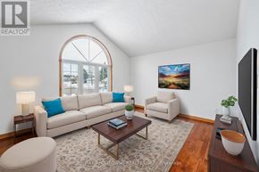 Brant (Paris) apartment for rent - A living room with a large window, a sofa, a chair, a coffee table, and a painting on the wall.