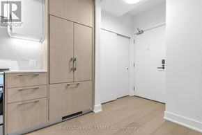 Toronto (Yonge-Eglinton) condo for rent - A room with a wooden floor and white walls, with a cabinet and drawers on the left and a door on the right.