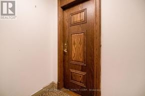 Mississauga (Central Erin Mills) condo for rent - A wooden door with a handle and a lock.