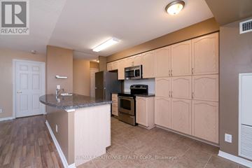 Mississauga (Central Erin Mills) condo for rent - A kitchen with wooden cabinets and a granite countertop.