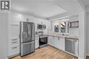 Hamilton townhouse for rent - A modern kitchen with stainless steel appliances and white cabinets.