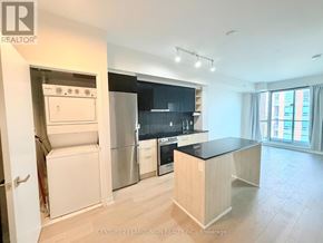 Toronto (Clanton Park) condo for rent - A kitchen with a white fridge and a black counter top.
