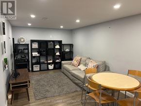 Toronto (Woburn) apartment for rent - A living room with a grey couch, a wooden table, and a television.