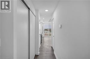 Brantford condo for rent - A long hallway with a door on the left and a window on the right.