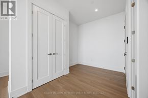 Toronto (Banbury-Don Mills) condo for rent - A white room with a wooden floor and a door on the right.