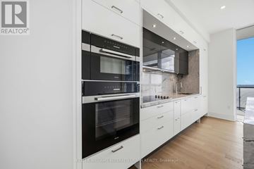 Toronto (Banbury-Don Mills) condo for rent - A modern kitchen with white cabinets and a black oven.