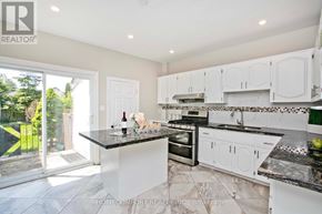 Toronto (Woodbine-Lumsden) apartment for rent - A kitchen with white cabinets and a black countertop.