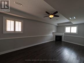 Innisfil (Alcona) apartment for rent - A room with a fireplace and a ceiling fan.