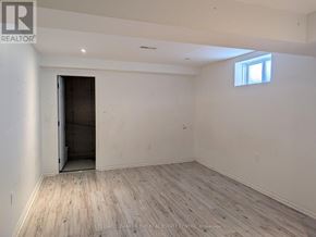 Innisfil (Alcona) apartment for rent - A room with wooden flooring and a doorway leading to another room.