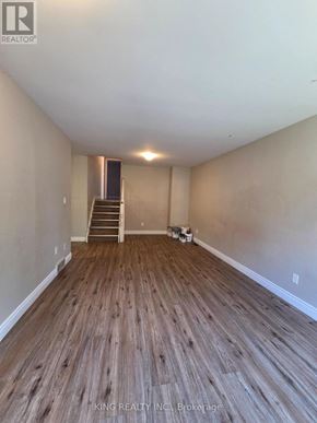 London East (East I) apartment for rent - A room with wooden flooring and a staircase in the background.