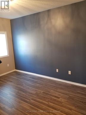 Mississauga (Churchill Meadows) condo for rent - A room with wooden flooring and a dark wall.