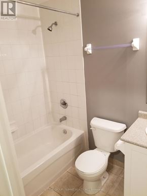 Mississauga (Churchill Meadows) condo for rent - A white toilet in a bathroom with a white tiled shower.