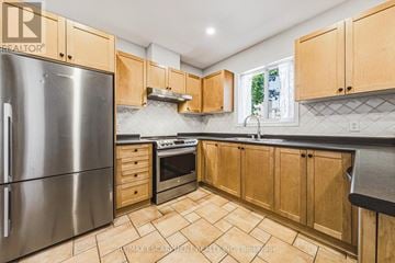 Burlington (Rose) townhouse for rent - A kitchen with wooden cabinets and a stainless steel refrigerator.