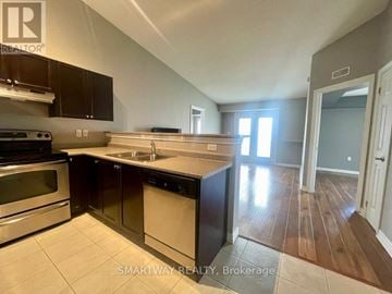 Milton (De Dempsey) condo for rent - A kitchen with dark brown cabinets and stainless steel appliances.