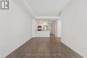 Toronto (Yorkdale-Glen Park) condo for rent - A spacious room with wooden flooring and white walls.