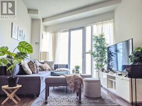 Mississauga (City Centre) condo for rent - A living room with a couch, a chair, a table, and a television.