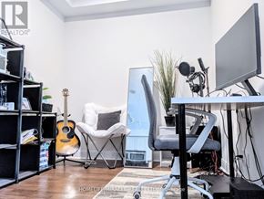 Mississauga (City Centre) condo for rent - A room with a guitar, chair, and a desk with a computer monitor.