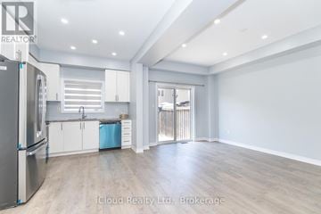 Hamilton (Stoney Creek Mountain) apartment for rent - A spacious kitchen with white cabinets and a refrigerator.