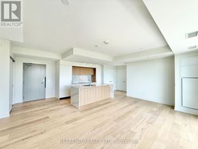 Toronto (Annex) condo for rent - A spacious room with wooden flooring and a kitchen area with white appliances.